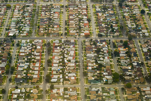 Large houses are spread out along a grid of streets, as seen from the air.